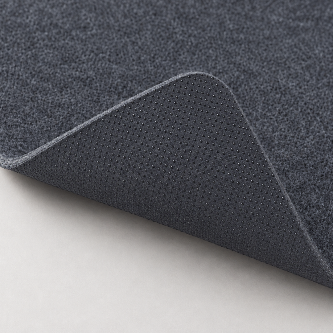 Corner of The Felt Desk Mat lifted to show the felt surface and anti slip backing