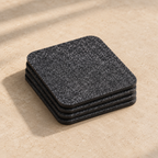 The Felt Coasters, four stacked, on an oat background