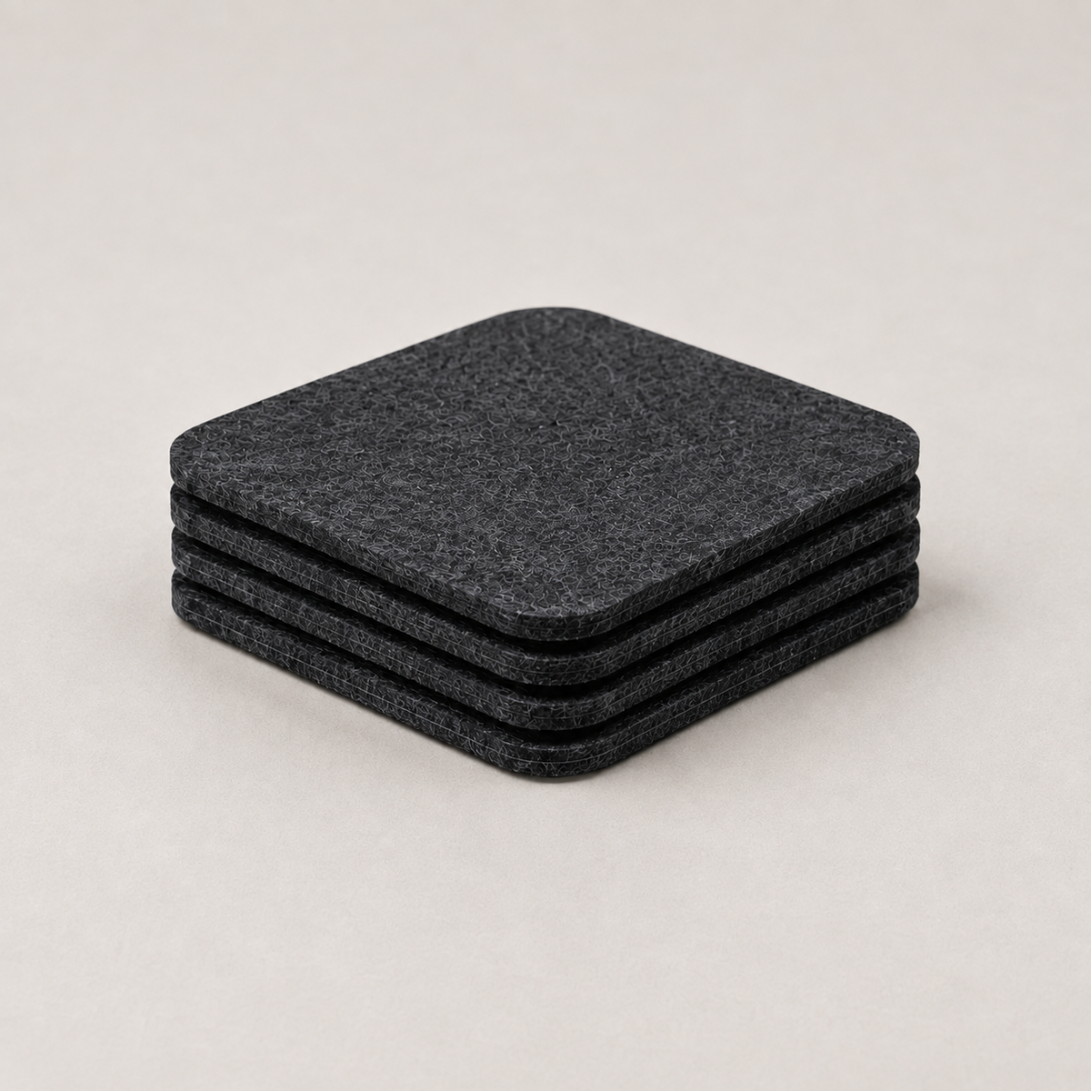 The Felt Coasters, four stacked, on a light background